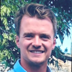 A man with brown hairs smiling at the camera